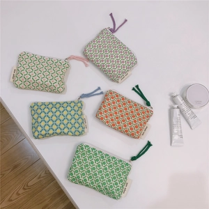 Close-up of five floral cotton mini pouches with simple wish labels and colorful zippers