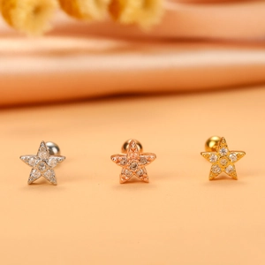 Vue macro détaillée des boucles d'oreilles étoiles en finitions argent, or rose et or