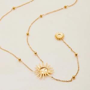Détail du collier en Y en acier inoxydable doré 18K avec pendentifs soleil et billes