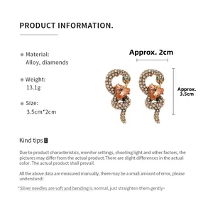 Detailed macro view of vintage snake earrings with rhinestones and orange heart stone