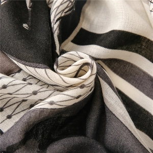 Close-up of black and white scarf showing soft cotton-linen texture and geometric patterns