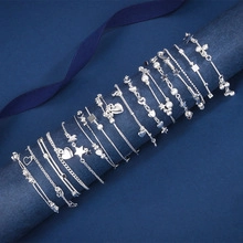 Macro shot of 15 various 925 silver bangles with star and heart pendants on blue silk