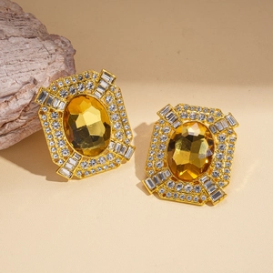 Détail de boucles d'oreilles vintage avec pierre ambre et bordure en strass