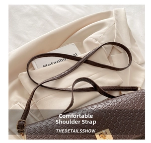 Detailed view of dark brown woven leather texture with gold metal buckle and strap
