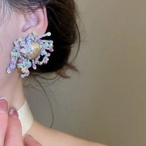 Detalle de primer plano de pendientes de flores con cuentas de colores estilo dopamina