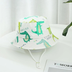 White children's bucket hat with green cartoon crocodile prints and adjustable chin strap
