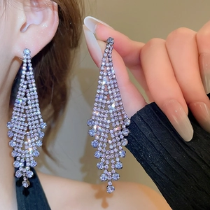 Close-up of sparkling rhinestone tassels on silver-plated long fringe drop earrings