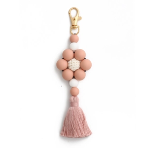 Close-up of pink and white silicone bead flower keychain with tassel and gold metal clasp