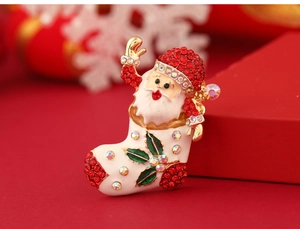 Macro shot of Santa Claus in Christmas stocking brooch with rhinestones and enamel