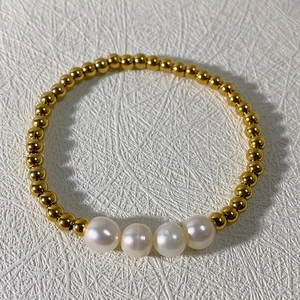 Vue détaillée des perles d'eau douce et des billes en acier inoxydable doré du bracelet