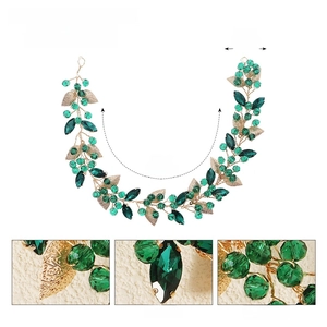 Detail view of bridal hair vine showing green crystals, golden leaves and dimensions