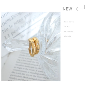 Detail of two 18K gold plated stainless steel star rings with inlaid zircon crystals