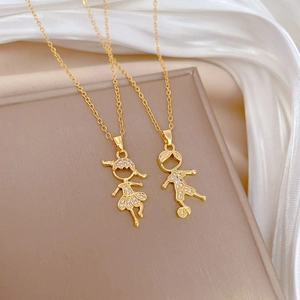 Close-up of gold titanium necklaces with diamond-encrusted boy and girl pendants