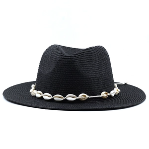 Detailed straw weave of black jazz hat featuring a natural white seashell decorative band