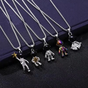 Five trendy astronaut pendant necklaces in various metallic finishes on a dark background