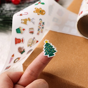 Close-up showing a cute Christmas sticker with reindeer design on a child's fingertip