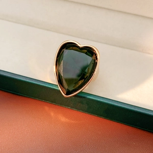Detailed side view of a large dark green heart zircon ring with a golden vintage finish