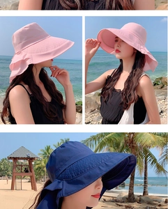 Zonnehoed met brede rand in roze en donkerblauw op strandachtergrond met een strik