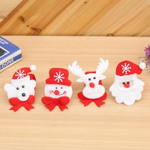 Flat lay of cute Christmas plush toys featuring Santa, snowman, bear, and reindeer on wood