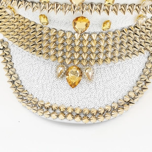 Close-up of luxury white sequin festival hat with gold studs and yellow gemstones