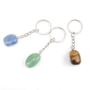 Three natural stone keychains in blue, green and brown tiger eye on white background