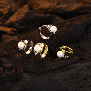 Elegant gold and silver pearl hoop earrings with S925 engraving on dark wood background