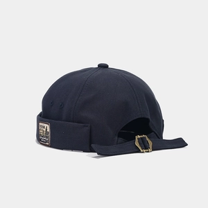 Detail of adjustable metal buckle and vintage side patch on navy blue canvas docker hat