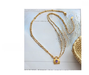 Detail of 18K gold double-layered satellite chain necklace with purple gemstone lock pendant