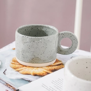 Handcrafted Nordic ceramic coffee mug with black splatter glaze and a large round handle