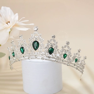 Detail of luxury crown with emerald green waterdrop gems and sparkling rhinestones
