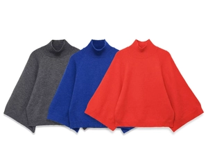Detailed close-up of loose-knit mock neck sweaters in dark gray, royal blue and red
