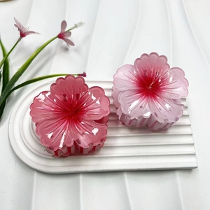 Dettaglio di fermagli per capelli a fiore rosa in resina su un vassoio bianco