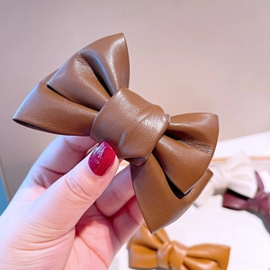 Grosse barrette à cheveux nœud en cuir synthétique marron avec texture détaillée