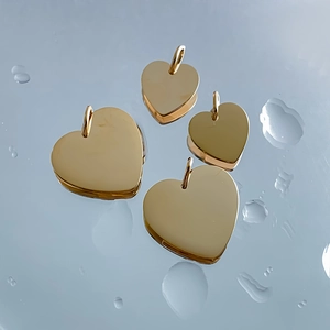 Set of four polished golden stainless steel heart pendants for DIY jewelry making.