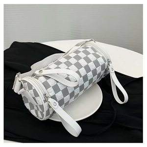 Detail view of cylinder shoulder bag with grey checkerboard pattern and ruffled texture