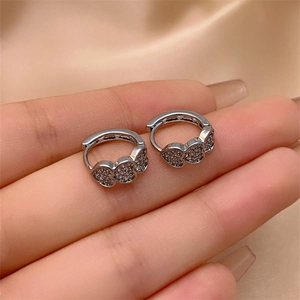 Close-up of silver triple heart hoop earrings with micro-set colorful zircons on silk
