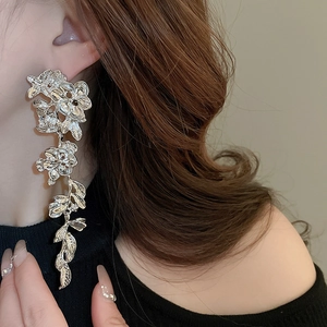 Silver long tassel earrings with metallic flowers and leaves shown on a model