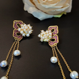 Vintage gold tassel earrings with purple crystals and freshwater pearls in a macro view