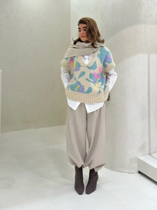 Detailed knit texture of colorful abstract floral vest paired with white shirt