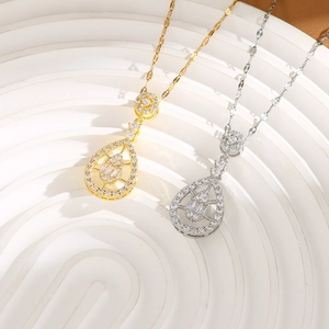 Detailed macro view of gold and silver teardrop pendants with micro-pave cubic zirconia