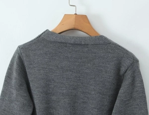 Gros plan sur la texture du dos et le motif en tricot du pull gris coupe ajustée