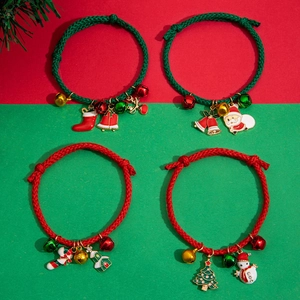 Close-up of red and green woven Christmas bracelets with Santa and bell enamel charms