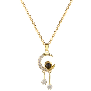 Elegant gold titanium moon tassel necklace with sparkling crystals on white background