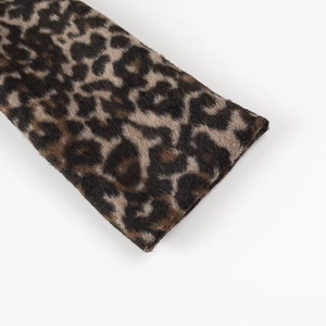 Dettaglio della trama del tessuto leopardato con pieghe morbide e materiale tessile di qualità