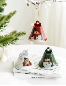 Close-up of red, green and white Christmas metal bells with Santa and snowman patterns