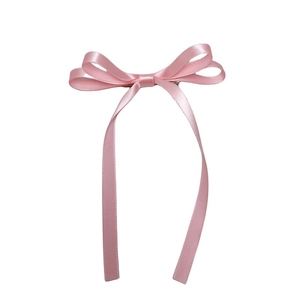 Detailed view of pink double-layered satin bow hair clip with long elegant ribbons