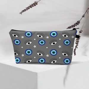 Detail of waterproof travel pouch featuring blue evil eye pattern and black zipper