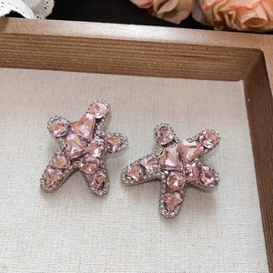 Macro detail of star hair clip with pink heart crystals and silver metal base