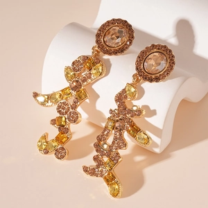 Macro shot of long drop earrings with amber crystals and gold frame on display