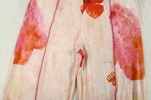 Détail du tissu à imprimé floral rose et orange avec texture tricotée et couture soignée
